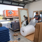 Power Movers team wrapping and packing large mirrors for a local move in Houston texas in a garage