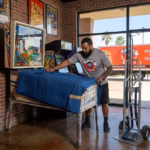 A power movers team member is wrapping a pinball machine for a local moving in houston texas